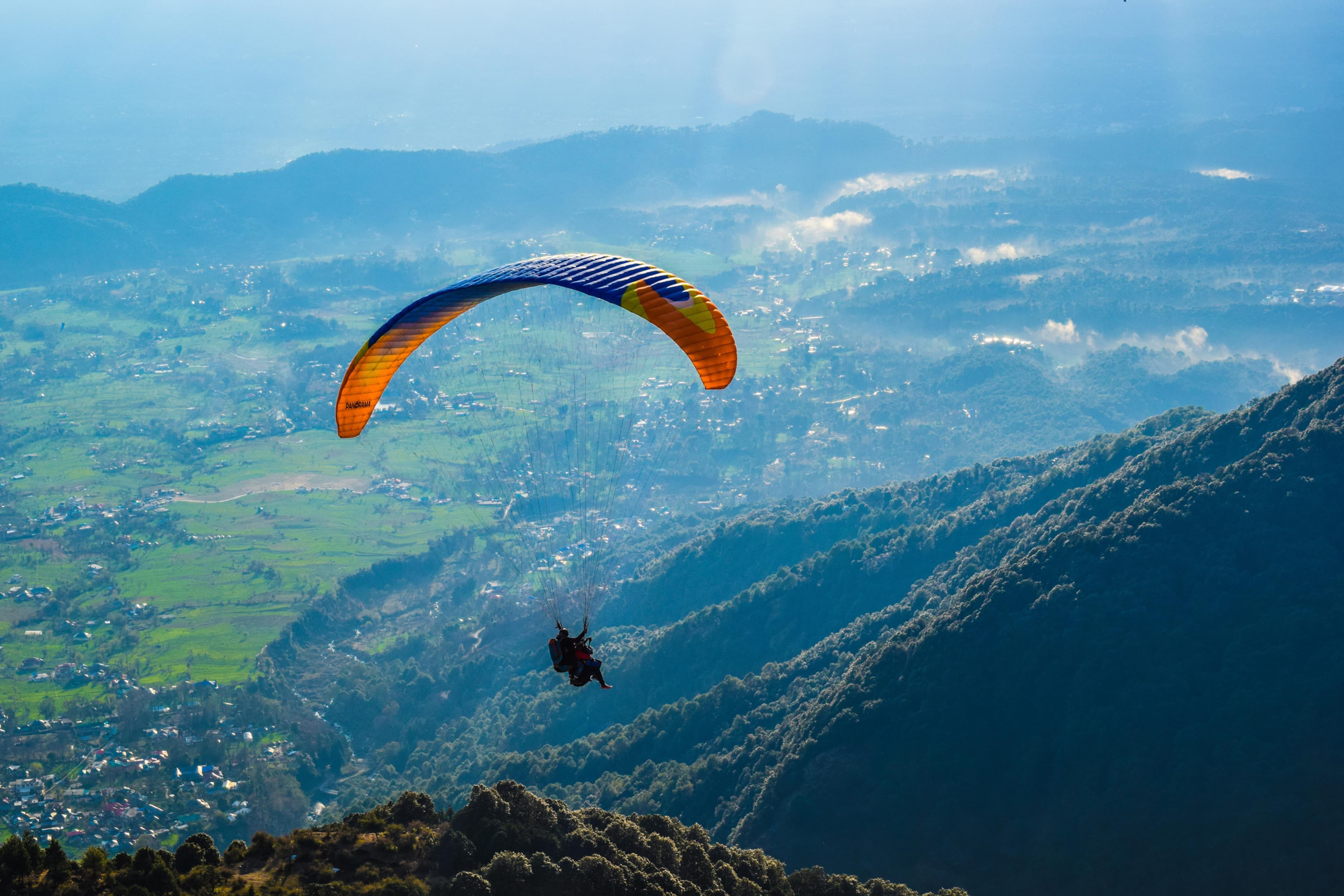 A paraglider crossing the Bir valley